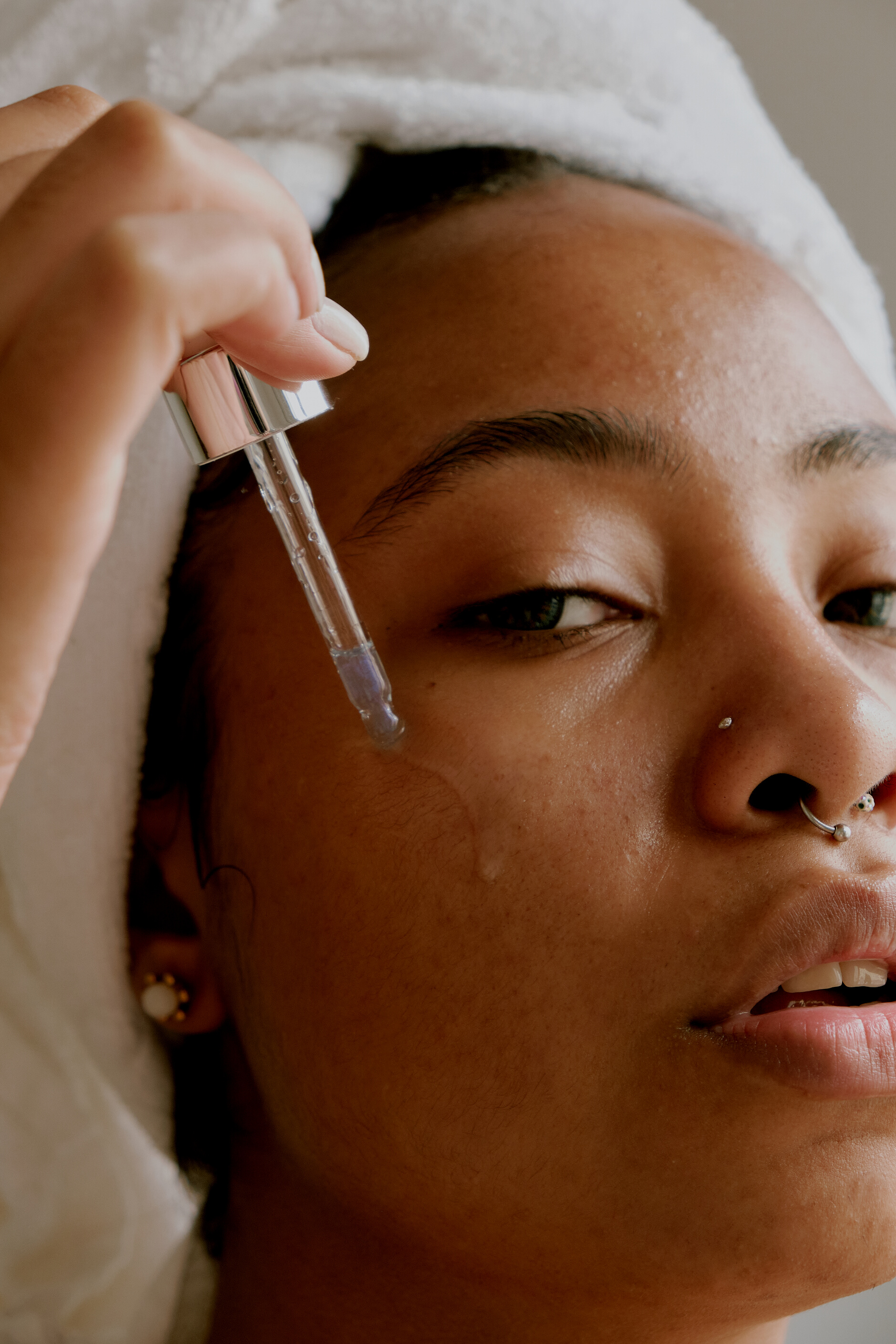 Woman Applying Serum on Face with a Dropper